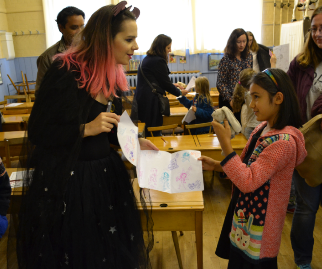 Girl giving Harriet Muncaster her Isadora Moon drawings