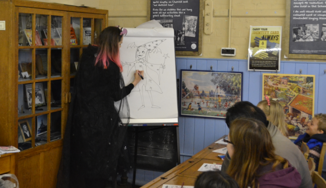 Harriet Muncaster drawing an audience member as a Vampire Wizard at Hitchin Childrens Book Festival